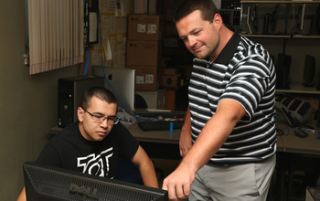 Josh Pauli working with a student in the lab.